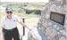 With Battle Canyon in the background, Dennie Siegrist stands by the monument that gives a brief description of events that occurred at the historic site. (Record Photo)