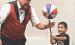 Juggler Richard Holmgren gets some assistance from Dexter Wiebe who balances a spinning basketball on a stick during the “Flying Debris” program held at the Scott County Library on Tuesday morning. (Record Photo)