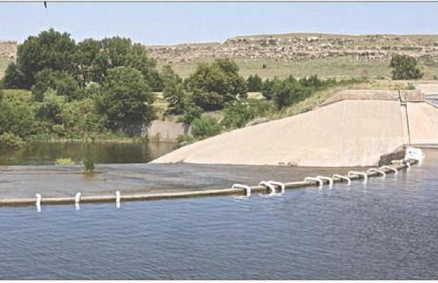 Since July 31, PVC pipe has been siphoning water from Lake Scott at the spillway with plans to eventually draw down the lake level by three to five feet. (Record Photo)