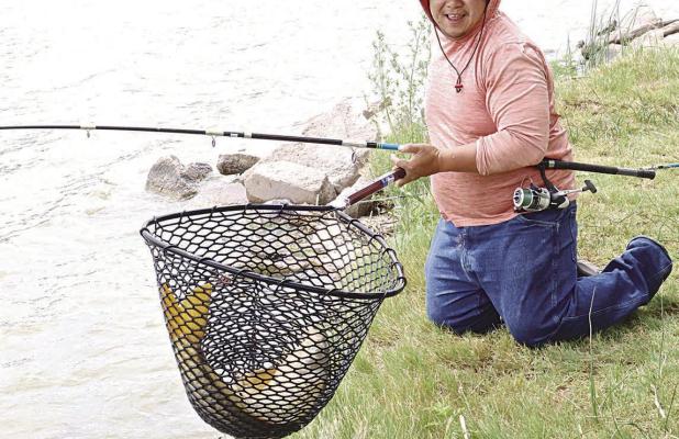 Johnny Mai, Garden City, with one of the carp he hauled in last Saturday afternoon. He landed the two large carp over the weekend, weighing in at 16.86 pounds and 15.18 pounds. (Record Photo)