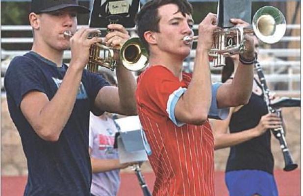 Scott Community High School marching band members Porter Wells (left) and Eli Geyer go through drills during Tuesday night’s camp session at the high school football field. The band concluded their camp on Wednesday evening with a performance for parent
