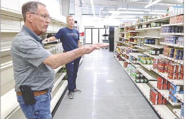 Randy Evans (foreground) and Casey Venters, director of the Lane County Community Foundation, discuss the work that’s being done to prepare the grocery store for its grand opening on June 27. (Record Photo)