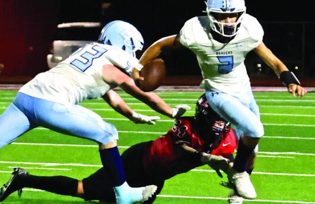 SCHS quarterback Drew Metzger avoids a tackle by a Great Bend defender as he breaks loose for a nine yard run during last Friday’s season opener. (Record Photo)