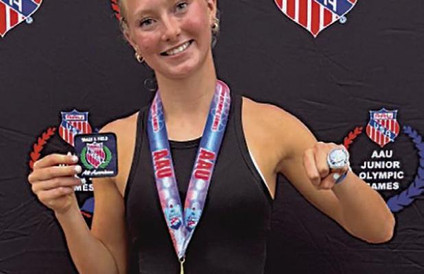 Maddie Goode with her awards, including a national championship ring, after winning the AAU pole vault competition in the 15-16-year division.