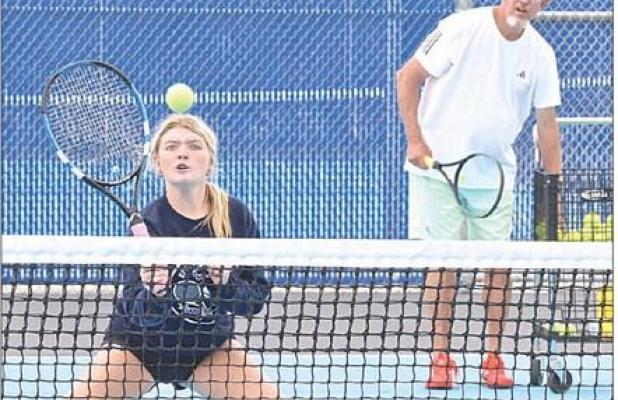 Allie Plummer prepares to hit a return shot at the net while longtime coach and clinician Dave Hawley looks on during the Scott City tennis camp. (Record Photo)