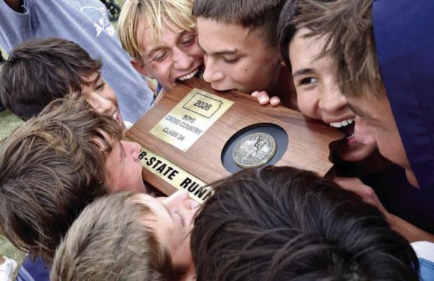 Taking a traditional bite into their sub-state plaque are SCHS cross-country team members (clockwise, from bottom left) Landry Beaton, Spencer Beaton, Michael Hermosillo, Carson Gabel, Asher Winter, Emilio Alarcon and Aaren Radke. (Record Photo)