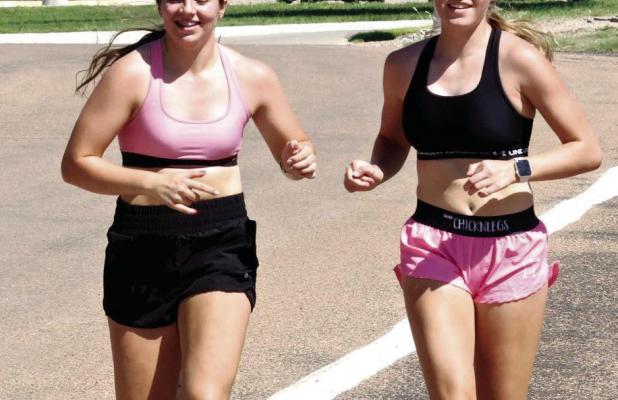 SCHS cross-country members Phebe Trout (left) and Hanna Winter on a timed run during Monday’s practice. (Record Photo)