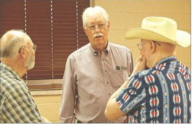 State Rep. Jim Minnix (R-Scott City) visits with two constituents during a candidate forum in Scott City last Thursday. (Record Photo)