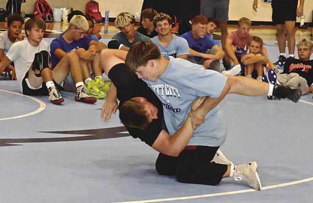 Jacob Frost throws his brother, Evan, to the mat while demonstrating a takedown during last week’s wrestling camp in Scott City. (Record Photo)