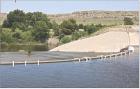 Since July 31, PVC pipe has been siphoning water from Lake Scott at the spillway with plans to eventually draw down the lake level by three to five feet. (Record Photo)