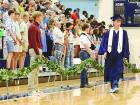 SCHS graduate Peyton Bergner walks past the ivy holders as he enters the gym floor of the Scott City Events Center at the start of Sunday’s commencement ceremony. (Record Photo)
