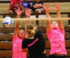 Crissa Irvin (left) and Megan Trout combine for a block during last week’s tournament action against Holcomb. (Record Photo) Position adjustments coming after tourneys to open the summer