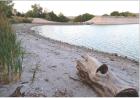 Siphon tubes at the spillway have drained about 3-1/2 feet of water so far from Lake Scott, which is evident by the amount of shoreline that’s been exposed. (Record Photo)