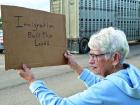 (Left) Jordan Rodriguez, 16, Scott City, shouts into a bullhorn as he leads a chant while Helen O’Bleness, Scott City, displays her support for immigrants. (Record Photos)