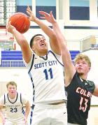 Scott City’s Junior Meza finishes off a drive in the paint with a basket over Colby’s Cobin Curry during last Thursday’s win on the home floor. R(ecord Photo)