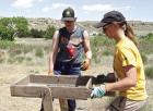 Megan Keitel (left) and Stephanie Cook sift through soil that has been removed from a dig site near the state park entrance. (Record Photo) Article Image Alt Text