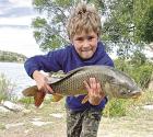 Dominic Koehn shows off the 9.4 pound carp he caught at Lake Scott.