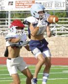 Senior Cayden Couchman makes a catch in front of a defender during an evening practice session. (Record Photo)