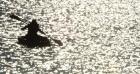 Lana Rodriguez, Scott City, is silhouetted against the early morning sun during the kayak phase of the Tri-Yak-a-Thon at Lake Scott last Saturday. (Record Photo) triathlon with a twist