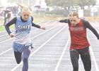 Under rainy conditions, SCHS senior Kinleigh Wren leans at the finish line to claim a silver medal in the 200m, just 1/100 of a second ahead of Hoisington’s Marley BIttel during the regional track meet at Beloit. (Record P hoto)