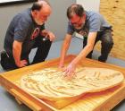 Paleontologist Chuck Bonner (right) shows Ray Troll the cluster of belemnite squid that are believed to have caused the death of a mosasaur fossil that was discovered by Bonner. It is yet another discovery by Bonner that could yield some interesting resul Bonner’s small bird fossil is yielding big results for researchers