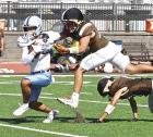 A Garden City defender leaps for Scott City senior Boston Louden after he breaks loose for a seven yard run. (Record Photo)