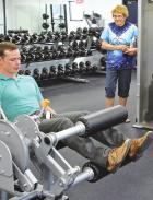 Scott County Hospital physical therapy Clay Mulligan demonstrates the proper way of using some of the equipment (above and below) and offers advice on Tuesday at the newly opened Scott Recreation Commission fitness center. (Record Photos) know pain, know gain