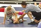 SCHS assistant coach Chaston Hoeme helps two wrestlers as they practice leg rides and how to turn an opponent to their back. (Record Photo) emphasis on the legs during SC camp