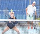 Allie Plummer prepares to hit a return shot at the net while longtime coach and clinician Dave Hawley looks on during the Scott City tennis camp. (Record Photo)