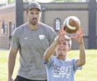 (Right) Former NFL player Garrett Griffin looks on as young athletes work on blocking drills during the recent football skills clinic. (Below) Michael Hermosillo, Scott City, catches a pass in front of former K-State player Sean Newlan. (Record Photos) Building a passion for the sport is a priority with young athletes