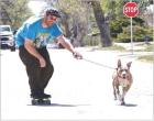 Allen Larson, Scott City, gets some assistance from his five-year-old pit bull, Wilbur, while skateboarding on a Scott City street recently. (Record Photo)