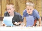 Testing their lung power with sail cars they made during a 4-H STEM program at the Wm. Carpenter 4-H Building last Friday were Garrett Wilson (left) and Case Crisler. The youth educational program was sponsored by the Kansas Energy Commission with assista