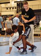 Colton McKiernan, an assistant wrestling coach at Fort Hays State University, works on takedown technique with young grapplers during the Scott City summer camp. (Recor d Photo) Article Image Alt Text