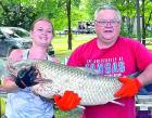 Emily Roberts is assisted by her dad, Ricky Wright, in holding up a 43 pound grass carp (aka, white amur) that she caught during the carp derby at Lake Scott State Park last Saturday. This is one that didn’t get away!