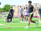Jason Ray (kneeling), formerly with Oklahoma State University, looks on as receivers go through drills during the SCHS football clinic. (Record Photo) it’s still the details
