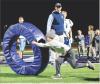 Jude McNary chases down a tackling ring while Scott Community High School football assistant coach Colborn Couchman looks on during a “skills and drills” night involving the SCHS football team and their Beaver Brothers. About 55 youth from kindergarte
